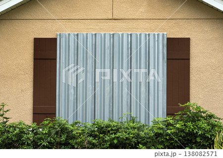 Steel storm shutters for hurricane protection of house windows. Protective measures before natural disaster in Florida 138082571