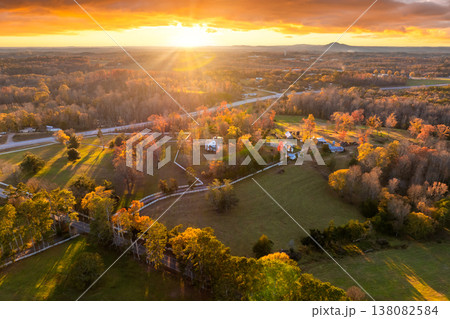 Spacious rural houses among yellow fall foliage in South Carolina suburbs. Beauty of seasonal colors in quiet countryside aria. Spacious rural houses among yellow fall foliage in South Carolina suburbs. Beauty of seasonal colors in quiet countryside aria. 138082584