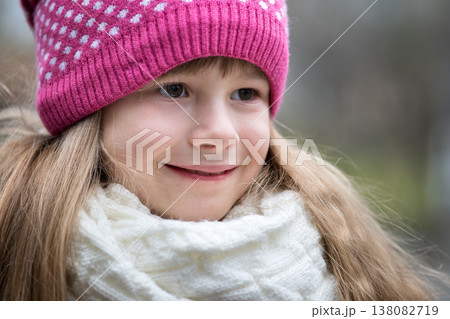 Pretty child girl in warm knitted winter clothes outdoors. Pretty child girl in warm knitted winter clothes outdoors. 138082719
