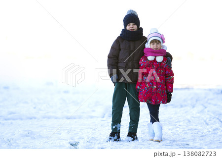 Portrait of two children boy and girl playing outdoors in winter snowy day 138082723