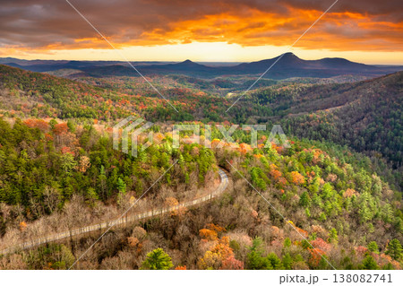 Peaceful mountain road in North Carolina during peak fall season at sunset. Appalachian landscape filled with vivid autumn colors Peaceful mountain road in North Carolina during peak fall season at sunset. Appalachian landscape filled with vivid autumn colors 138082741
