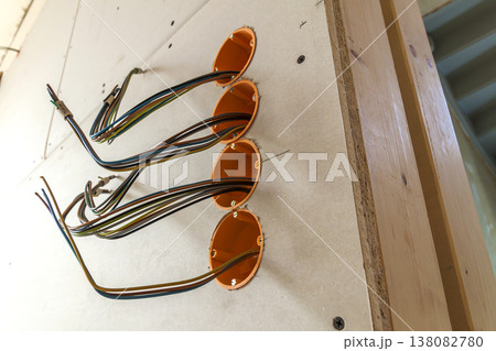 New electrical installation, socket plastic boxes and electrical cables on the wall, renovation concept. Electrical wiring installation. 138082780
