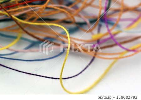 Multi-colored tangled colorful needlecraft silk thread rope. Macro shot. Abstract colors background Multi-colored tangled colorful needlecraft silk thread rope. Macro shot. Abstract colors background 138082792