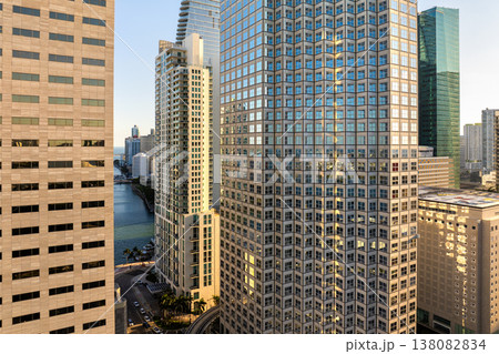 Miami, coastal city in Florida at sunset. Waterfront skyscraper buildings in downtown district of USA urban area. American megapolis with business financial district Miami, coastal city in Florida at sunset. Waterfront skyscraper buildings in downtown district of USA urban area. American megapolis with business financial district 138082834