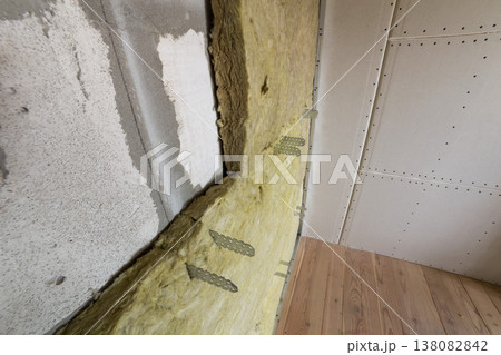 Metal frame for future walls with drywall plates insulated with rock wool and fiberglass insulation staff for cold barrier. Comfortable warm home, economy, construction and renovation concept. 138082842