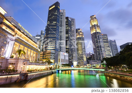 Night view of the Fullerton Hotel, Cavenagh Bridge, and financial district skyscrapers along the Singapore River. 138082856