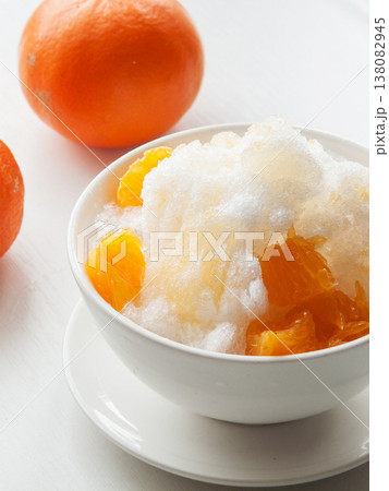 Shaved ice Kakigori granita fruit dessert for summer made of ice with juice sauce in bowl on table. Shaved ice Kakigori granita fruit dessert for summer made of ice with juice sauce in bowl on table. 138082945