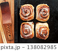 Freshly baked homemade cinnamon rolls with sweet cream cheese lying on oven pan. 138082985