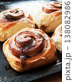 Freshly baked homemade cinnamon rolls with sweet cream cheese lying on oven pan. 138082986