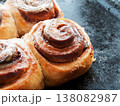 Freshly baked homemade cinnamon rolls with sweet cream cheese lying on oven pan. 138082987