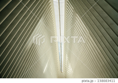 A close view of the white architectural ribs and skylight inside the Oculus in New York City. The repeating geometric lines create a futuristic and minimalist interior design. A close view of the white architectural ribs and skylight inside the Oculus in New York City. The repeating geometric lines create a futuristic and minimalist interior design. 138083411