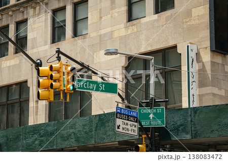 Street signs for Barclay Street and Church Street are mounted beneath traffic lights in Lower Manhattan, New York City. Bus lane and route signs highlight urban transportation infrastructure. 138083472