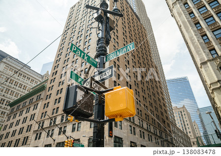 Street signs for Broadway and Park Row are mounted on a pole in Lower Manhattan, New York City. Tall office buildings surround the busy urban intersection in downtown NYC. 138083478