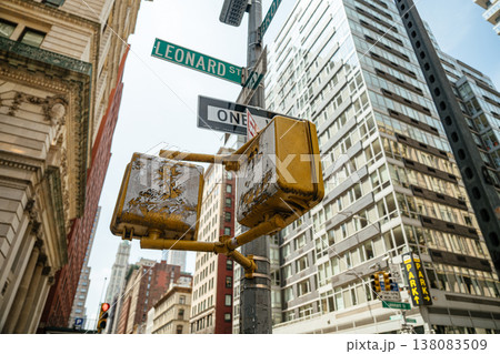 A Leonard Street and One Way sign stand against tall Manhattan buildings in New York City. The urban street scene highlights traffic signals and city infrastructure. A Leonard Street and One Way sign stand against tall Manhattan buildings in New York City. The urban street scene highlights traffic signals and city infrastructure. 138083509