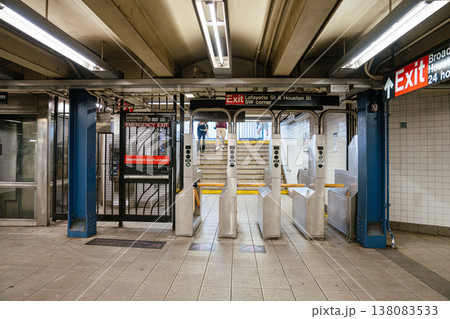 Metal turnstiles and exit gate inside a New York City subway station. Underground metro entrance with security barriers and transportation infrastructure. 138083533