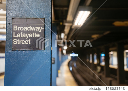 Close view of Broadway Lafayette Street subway station sign on blue steel column in Manhattan. Underground New York City metro platform with blurred railway tracks and urban transportation 138083548