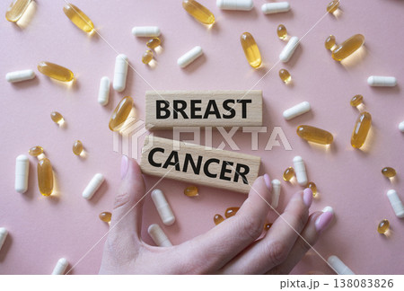 Breast cancer symbol. Wooden blocks with words Breast cancer. Beautiful pink background with pills. Doctor hand. Medicine and Breast cancer concept. Copy space. 138083826