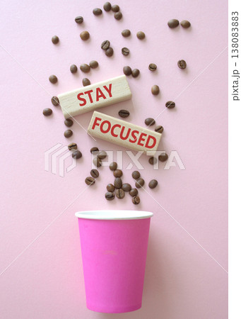 Stay Focused symbol. Concept word Stay Focused on wooden blocks. Beautiful pink background with coffee cup. Business and Stay Focused concept. Copy space Stay Focused symbol. Concept word Stay Focused on wooden blocks. Beautiful pink background with coffee cup. Business and Stay Focused concept. Copy space 138083883