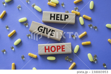 Help Give Hope symbol. Concept word Help Give Hope on wooden blocks. Beautiful purple background with pills. Medicine and Help Give Hope concept. Copy space Help Give Hope symbol. Concept word Help Give Hope on wooden blocks. Beautiful purple background with pills. Medicine and Help Give Hope concept. Copy space 138083953