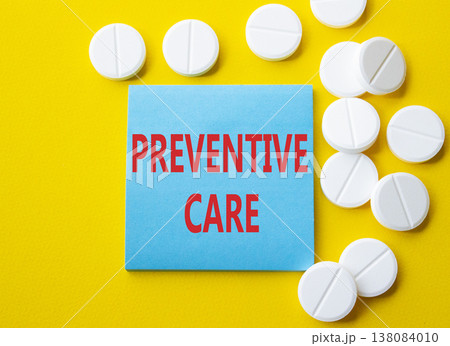 Preventive Care symbol. Concept word Preventive Care on blue note. Beautiful yellow background with pills. Medicine and Preventive Care concept. Copy space 138084010