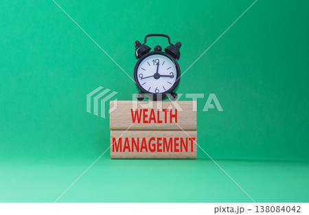 Wealth Management symbol. Concept words Wealth Management on wooden blocks. Beautiful green background with alarm clock. Business and Wealth Management concept. Copy space 138084042