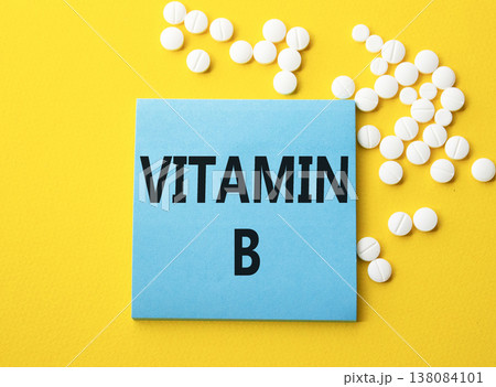 Vitamin B symbol. Concept word Vitamin B on blue note. Beautiful yellow background with pills. Medicine and Vitamin B concept. Copy space 138084101