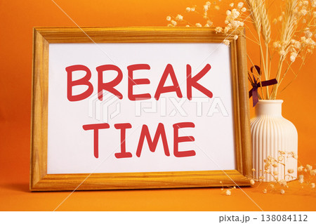 Break Time symbol. Concept words Break Time on beautiful wooden picture frame. Beautiful orange background with flower vase. Business and Break Time concept. Copy space. Break Time symbol. Concept words Break Time on beautiful wooden picture frame. Beautiful orange background with flower vase. Business and Break Time concept. Copy space. 138084112