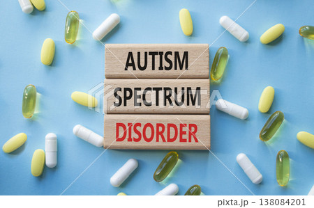 Autism Spectrum Disorder symbol. Concept word Autism Spectrum Disorder on wooden blocks. Beautiful blue background with pills. Medicine and Autism Spectrum Disorder concept. Copy space Autism Spectrum Disorder symbol. Concept word Autism Spectrum Disorder on wooden blocks. Beautiful blue background with pills. Medicine and Autism Spectrum Disorder concept. Copy space 138084201