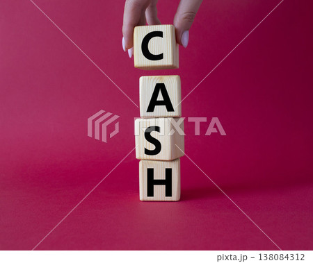 Cash symbol. Concept word Cash on wooden cubes. Beautiful red background. Businessman hand. Business and Cash concept. Copy space. Cash symbol. Concept word Cash on wooden cubes. Beautiful red background. Businessman hand. Business and Cash concept. Copy space. 138084312