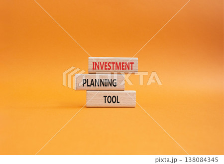 Investment planning tool symbol. Concept word Investment planning tool on wooden blocks. Beautiful orange background. Business and Investment planning tool. Copy space 138084345