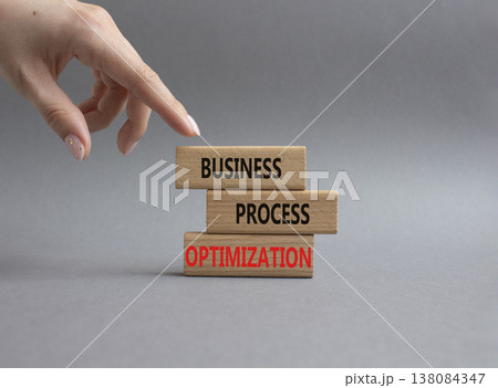 Business Process Optimization symbol. Concept word Business Process Optimization on wooden blocks. Beautiful grey background. Businessman hand. Business and Business Process Optimization. Copy space 138084347