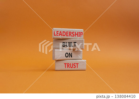 LEADERSHIP symbol. Wooden blocks with words LEADERSHIP BUILT ON TRUST. Beautiful orange background. Business and LEADERSHIP concept. Copy space 138084410
