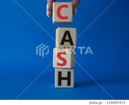 Cash symbol. Concept word Cash on wooden cubes. Beautiful blue background. Businessman hand. Business and Cash concept. Copy space. 138084431