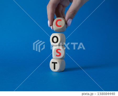Cost symbol. Concept word Cost on wooden cubes. Beautiful blue background. Businessman hand. Business and Cost concept. Copy space. Cost symbol. Concept word Cost on wooden cubes. Beautiful blue background. Businessman hand. Business and Cost concept. Copy space. 138084440