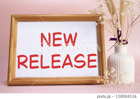 New Release symbol. Concept words New Release on beautiful wooden picture frame. Beautiful pink background with flower vase. Business and New Release concept. Copy space. New Release symbol. Concept words New Release on beautiful wooden picture frame. Beautiful pink background with flower vase. Business and New Release concept. Copy space. 138084516
