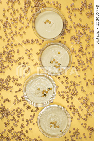Top view of healthy chickpea hummus on bright yellow. 138085749