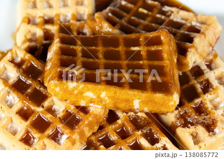 Delicious Belgian waffles topped with sweet caramel syrup close up. 138085772