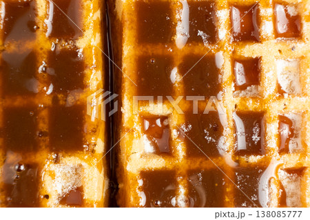 Sweet dessert background with waffles and flowing caramel syrup. 138085777