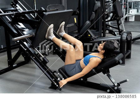 Young woman is exercising, focusing on building leg muscles 138086585
