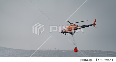 Helicopter in Action with Firefighting Bucket Helicopter in Action with Firefighting Bucket 138086624