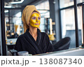 confident woman observing her refreshed skin in mirror after gold face mask procedure, contemporary 138087340