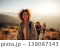 confident middle-aged woman in her 30s leading friends along mountain ridge, dynamic walking pose, 138087343