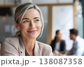 attractive middle-aged woman in her 30s having a friendly discussion with coworkers in open space 138087358