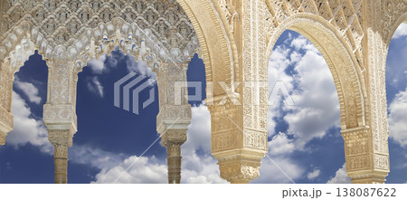 Arches in Islamic (Moorish) style (against the background of a beautiful sky with clouds) in Alhambra, Granada, Spain Arches in Islamic (Moorish) style (against the background of a beautiful sky with clouds) in Alhambra, Granada, Spain 138087622