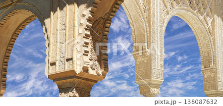 Arches in Islamic (Moorish) style (against the background of a beautiful sky with clouds) in Alhambra, Granada, Spain Arches in Islamic (Moorish) style (against the background of a beautiful sky with clouds) in Alhambra, Granada, Spain 138087632