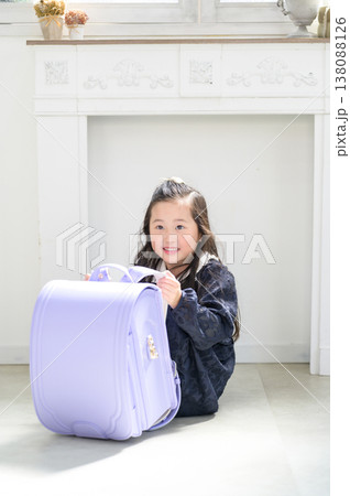 ランドセルの後ろで体育座りをする日本人の女の子 ランドセルの後ろで体育座りをする日本人の女の子 138088126