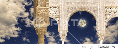 Arches in Islamic (Moorish) style (against the background of a beautiful evening sky with clouds with the super moon) in Alhambra, Granada, Spain 138088179