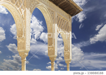 Arches in Islamic (Moorish) style (against the background of a beautiful sky with clouds) in Alhambra, Granada, Spain Arches in Islamic (Moorish) style (against the background of a beautiful sky with clouds) in Alhambra, Granada, Spain 138088188