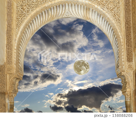 Arches in Islamic (Moorish) style (against the background of a beautiful evening sky with clouds with the super moon) in Alhambra, Granada, Spain 138088208