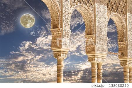 Arches in Islamic (Moorish) style (against the background of a beautiful evening sky with clouds with the super moon) in Alhambra, Granada, Spain 138088239